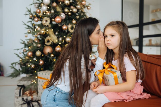 Giovane madre che calma la sua triste figlia neonata seduta