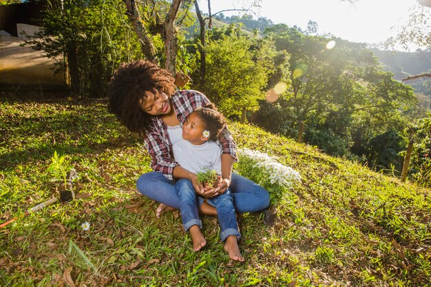 Giovane madre con figlia seduta su una collina