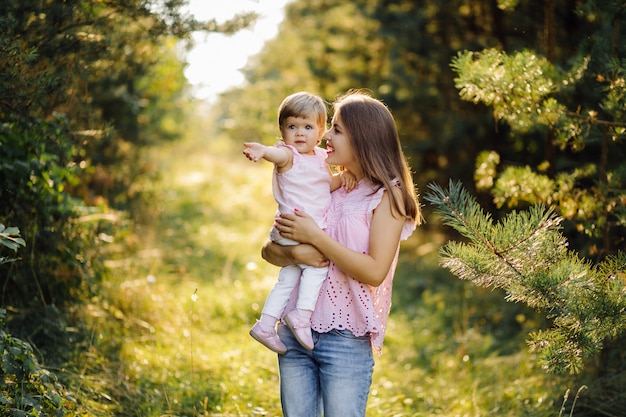 Giovane madre con il suo adorabile piccolo bambino nella foresta