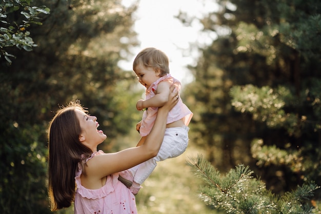 Giovane madre con il suo adorabile piccolo bambino nella foresta