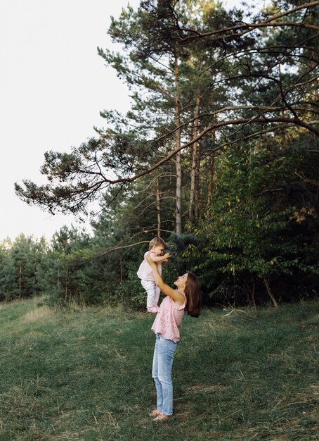 Giovane madre con il suo adorabile piccolo bambino nella foresta