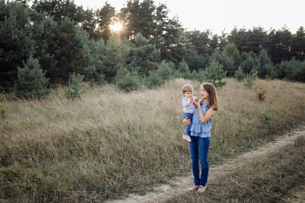 Giovane madre con il suo adorabile piccolo bambino nella foresta