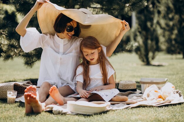 Giovane madre con la figlia che ha picnic nel cortile