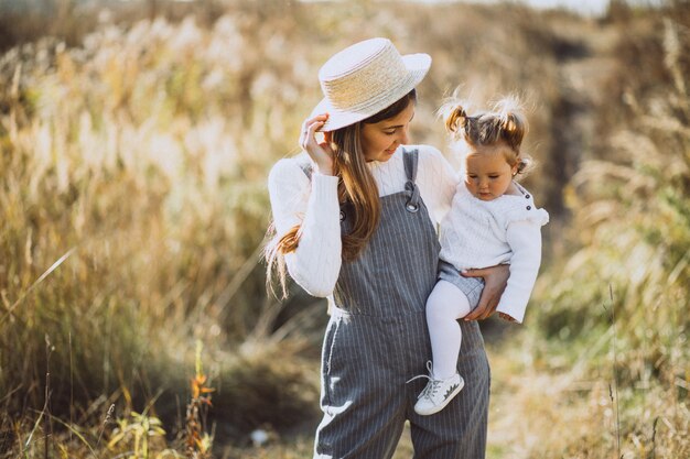 Giovane madre con la sua piccola figlia in un campo di autunno