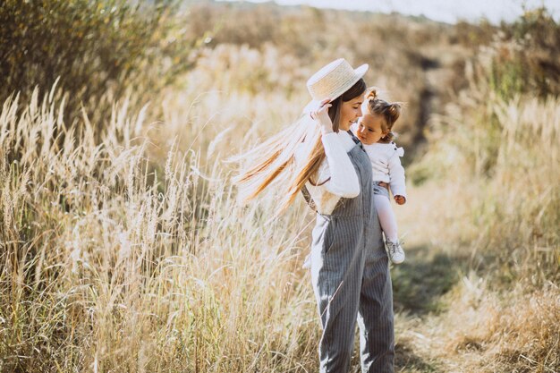 Giovane madre con la sua piccola figlia in un campo di autunno