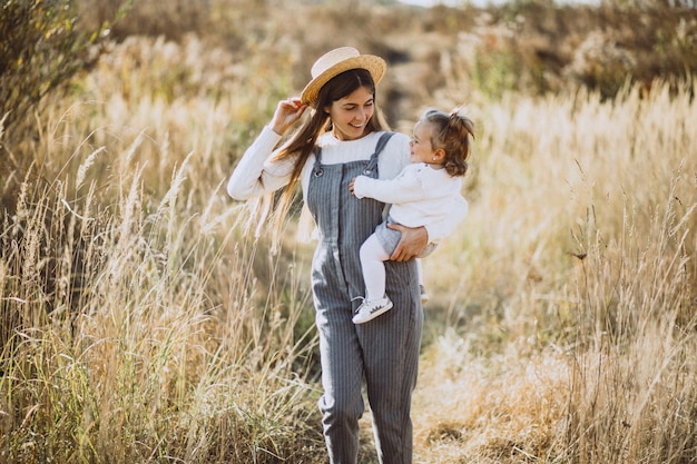 Giovane madre con la sua piccola figlia in un campo di autunno