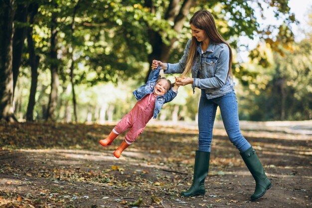 Giovane madre con la sua piccola figlia in un parco di autunno