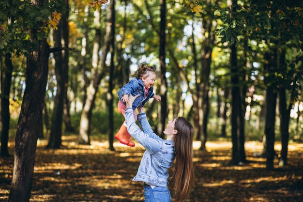 Giovane madre con la sua piccola figlia in un parco di autunno