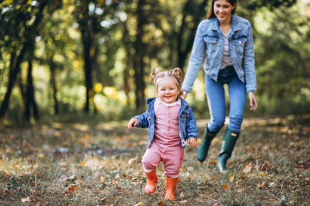 Giovane madre con la sua piccola figlia in un parco di autunno