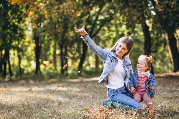 Giovane madre con la sua piccola figlia in un parco di autunno