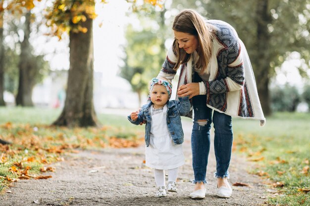 Giovane madre con la sua piccola figlia in un parco in autunno