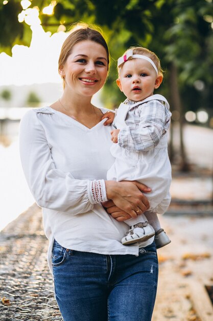 Giovane madre con la sua piccola figlia in un parco in autunno