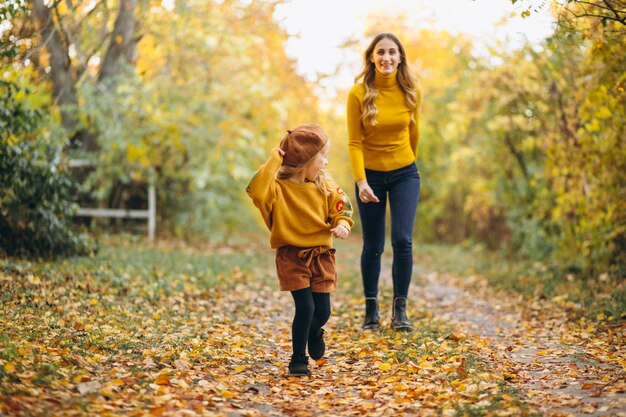 Giovane madre con la sua piccola figlia in un parco in autunno