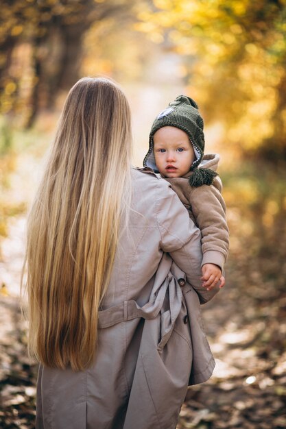 Giovane madre con la sua piccola figlia in un parco in autunno