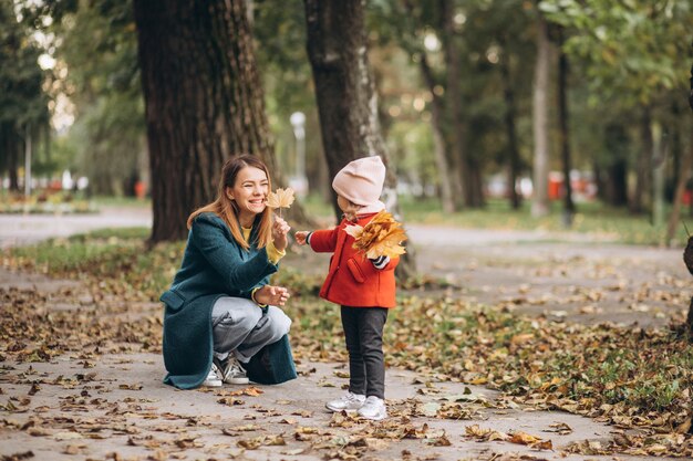 Giovane madre con la sua piccola figlia in un parco in autunno