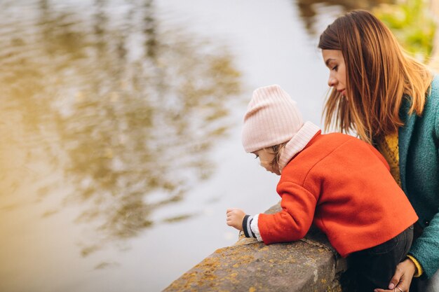 Giovane madre con la sua piccola figlia in un parco in autunno