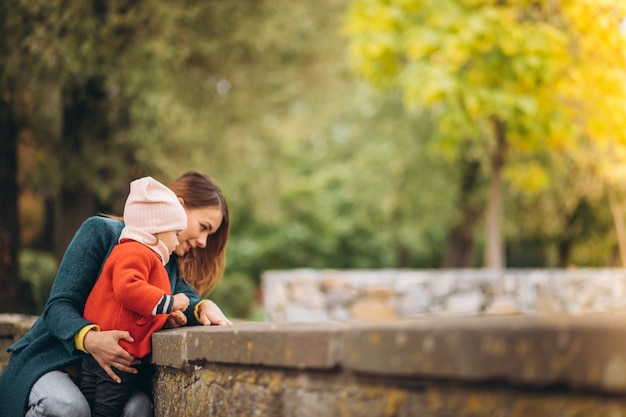 Giovane madre con la sua piccola figlia in un parco in autunno