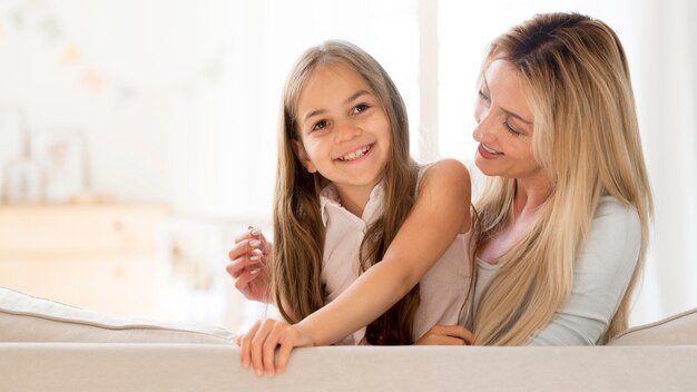 Giovane madre e figlia di smiley che propongono insieme