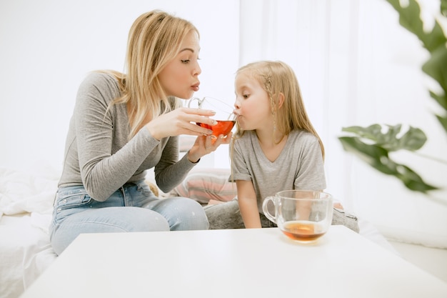 Giovane madre e la sua piccola figlia a casa al mattino pieno di sole