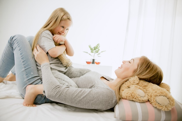 Giovane madre e la sua piccola figlia a casa al mattino pieno di sole.