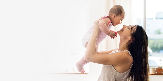 Giovane mamma che tiene il suo bambino nello spazio vuoto dell'aria