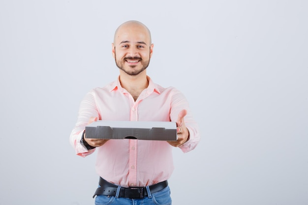 Giovane maschio che mostra dando gesto in camicia, jeans e guardando positivo, vista frontale.