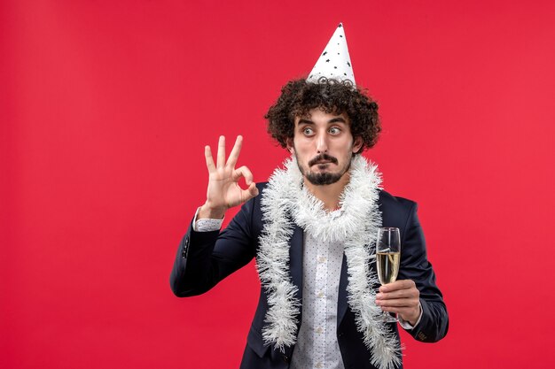 Giovane maschio di vista frontale che celebra un altro anno sull'essere umano di feste del partito della parete rossa