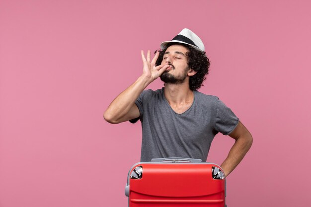 Giovane maschio di vista frontale che prepara per la vacanza in cappello sullo spazio rosa pink