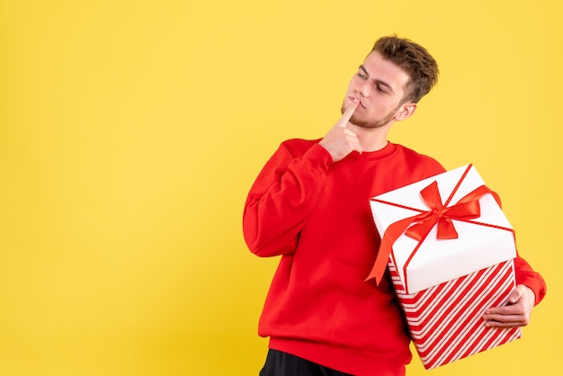 Giovane maschio di vista frontale in camicia rossa con regalo di Natale