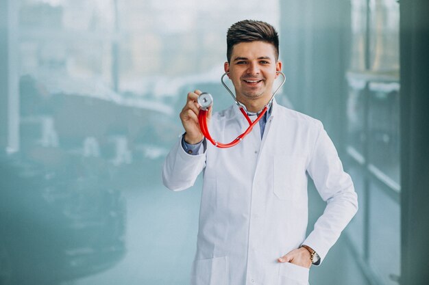 Giovane medico bello in un abito medico con lo stetoscopio