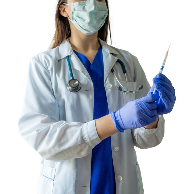 Giovane medico caucasico femminile in un'uniforme medica e guanti che preparano la siringa per un'iniezione