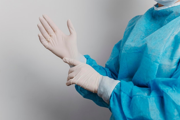 Giovane medico che indossa guanti chirurgici
