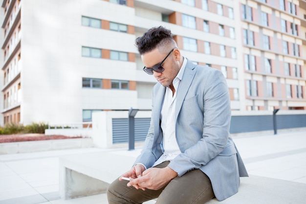 Giovane messaggio di texting serio dell&#39;uomo d&#39;affari sul banco