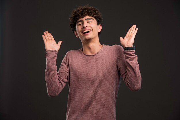 Giovane modella con i capelli ricci che applaudono.