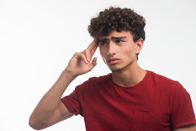 Giovane modello con il pensiero dei capelli ricci.