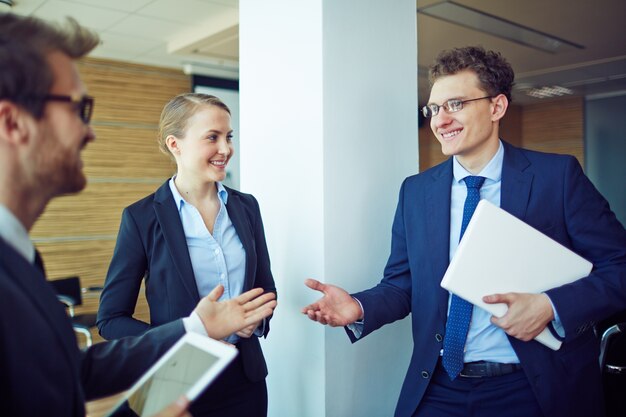 Giovane operaio sorridente con i suoi colleghi di lavoro