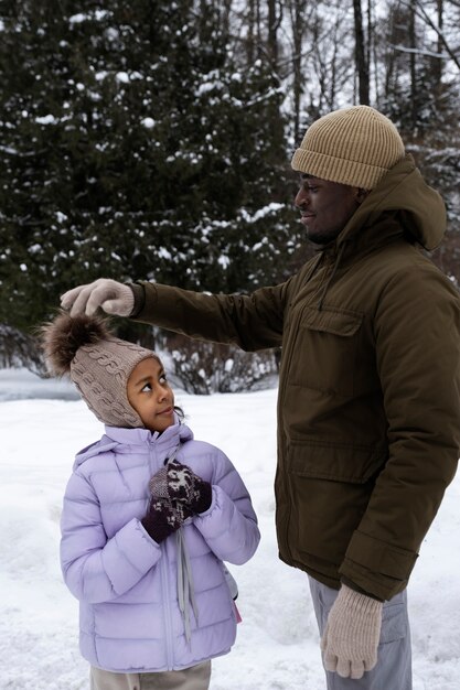 Giovane padre che si gode una giornata invernale innevata con sua figlia