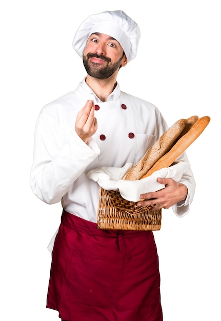 Giovane panettiere che tiene un po &#39;di pane e facendo gesto di denaro