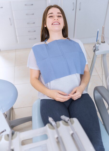Giovane paziente femminile che si siede sulla sedia in clinica dentale
