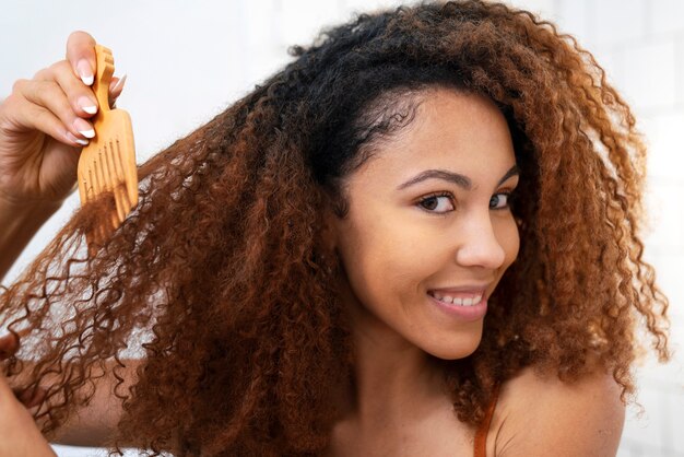 Giovane persona di colore che si prende cura dei capelli afro