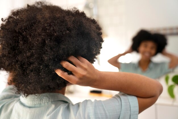 Giovane persona di colore che si prende cura dei capelli afro