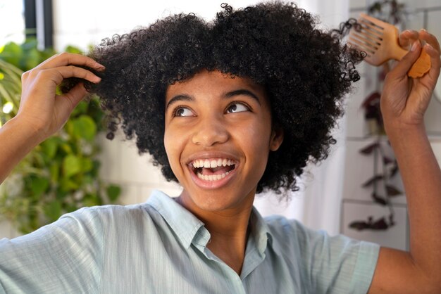 Giovane persona di colore che si prende cura dei capelli afro