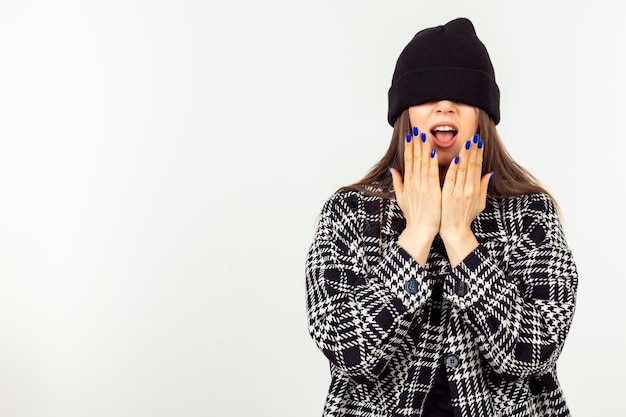 Giovane ragazza che indossa cappello e stare su sfondo bianco