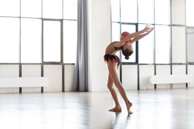 Giovane ragazza che si allena in ginnastica