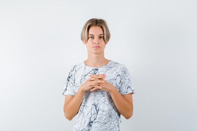 Giovane ragazza che tiene le sue mani intrecciate su sfondo bianco