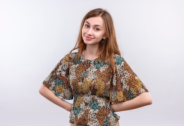 Giovane ragazza con i capelli lunghi che indossa abiti colorati felice e positivo guardando fiducioso sorridente