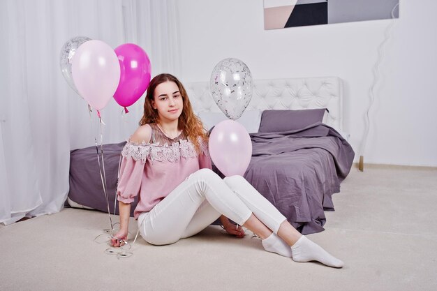 Giovane ragazza con palloncini sul letto poste in studio