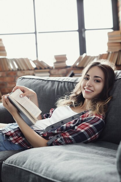 Giovane ragazza dell'adolescente che legge un libro a casa