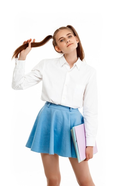 Giovane ragazza emotiva in posa uniforme isolata su sfondo bianco
