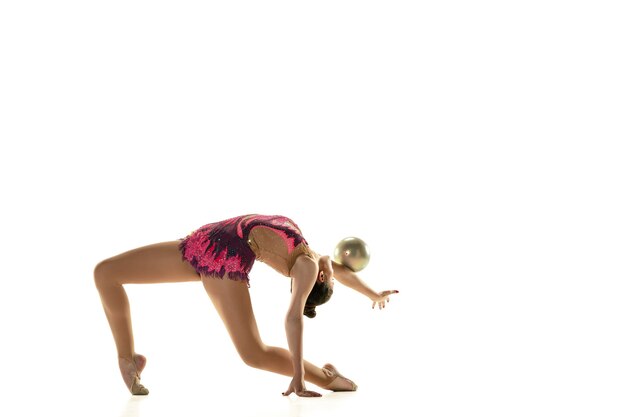 Giovane ragazza flessibile isolata su sfondo bianco. Modello femminile adolescente come artista di ginnastica ritmica che pratica con attrezzature.